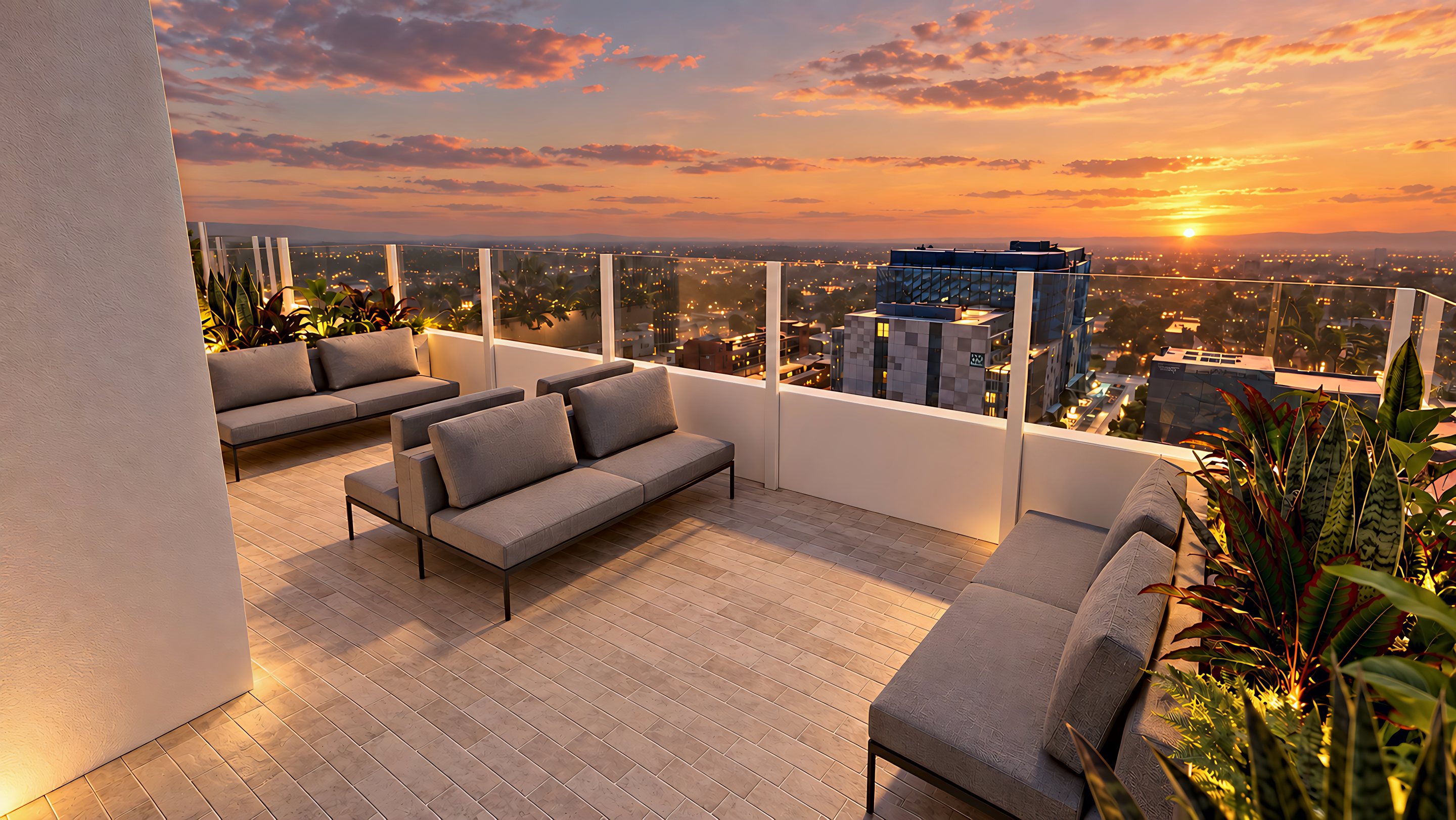 Rooftop lounge seating area with sofas facing the Adelaide skyline at sunset.